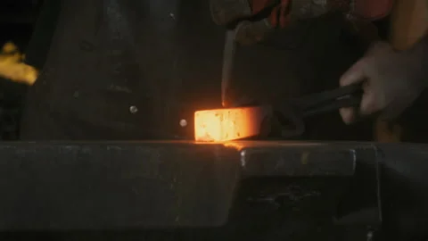 Blacksmith hitting a chisel into smelted metal Stock Footage 275502948
