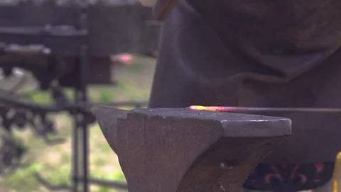 Blacksmith hitting glowing hot metal rod. Presentation at Slavic and old Stock Footage 113556965