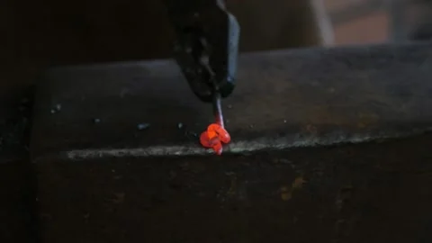Blacksmith is hitting a red metallic stick with a hammer making something Stock-Footage 148441234