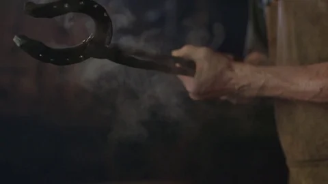 Blacksmith is holding hot horseshoe 動画素材 76737705