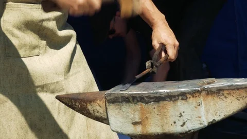 A Blacksmith Holding a Massive Hammer Banging Hot Metal Bar on Anvil. Vidéo 110836507