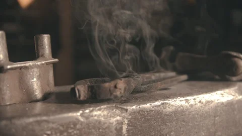 A blacksmith instruments on the anvil covered in cold steam Stock Footage 125365511