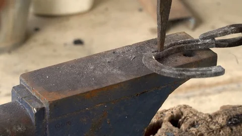 The blacksmith kicks a horseshoe close up Stock Footage 99529883