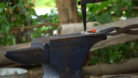 The blacksmith kicks a horseshoe close up Stock Footage 100356782