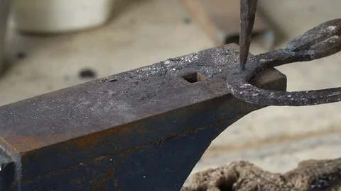 The blacksmith kicks a horseshoe close up Stock Footage 100356847