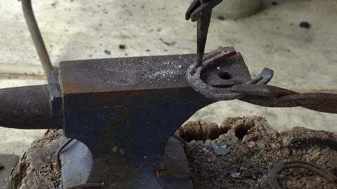The blacksmith kicks a horseshoe close up Stock Footage 100433649