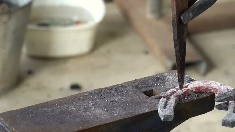 The blacksmith kicks a horseshoe close up Stock Footage 100433987