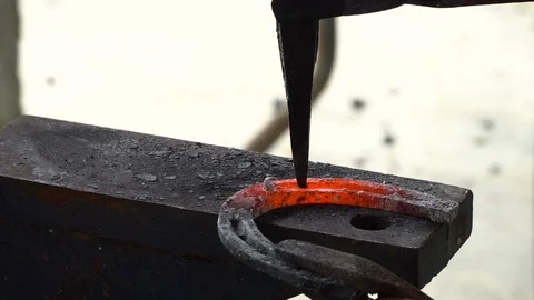 The blacksmith kicks a horseshoe close up Stock Footage 100438003