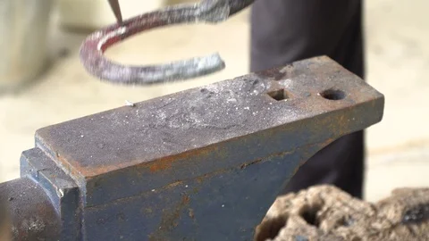 The blacksmith kicks a horseshoe close up Stock Footage 100440324