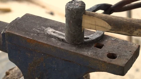 The blacksmith kicks a horseshoe close up Stock Footage 100457778