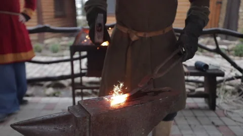 Blacksmith knocks on red-hot metal, sparks Stock Footage 167883619