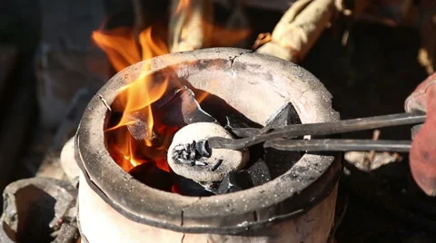 The blacksmith lays the ore into the crucible Stock Footage 54687970
