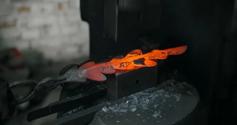 Blacksmith makes a decorative red-hot forged metal product with hydraulic hammer Stock Footage 151746602