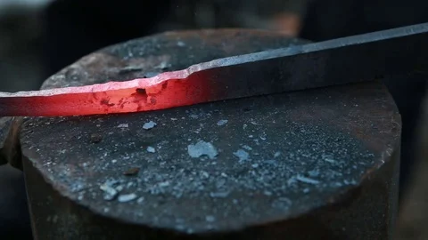Blacksmith makes form from hot, glowing iron metal Stock Footage 71935821