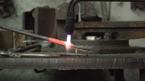 The blacksmith makes metal candle holder with rose and horseshoe. slow more Video stock 75489958