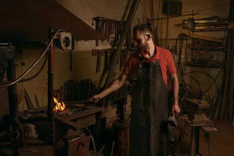 Blacksmith making flames for work in workshop Stock Photos