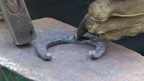 Blacksmith making horseshoe Stock Footage