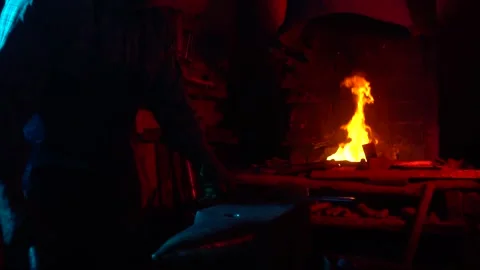 Blacksmith, A man blacksmith forging a hot knife blade using a hammer 库存影片 150736103