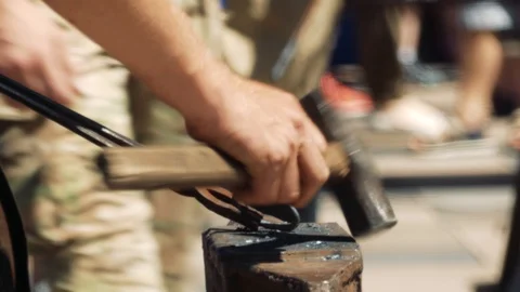 The blacksmith manually forged a heart out of metal. With a hammer and tongs, Stock-Footage 110836466