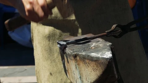 The blacksmith manually forges a rose from metal with the help of a hammer, a Stock-Footage 110836528