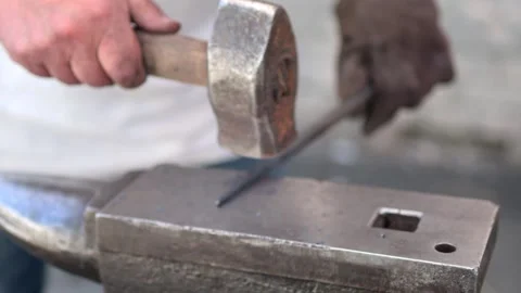 Blacksmith manually forging the heated metal Stock Footage 258620325