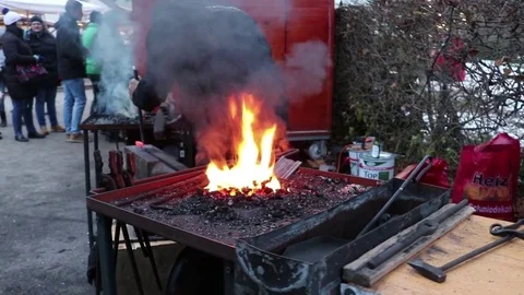 The blacksmith manually forging the molten metal on the anvil in smithy with Vidéo 83475975
