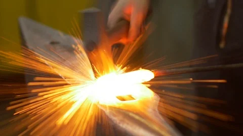The blacksmith manually forging the molten metal on the anvil Stock Footage