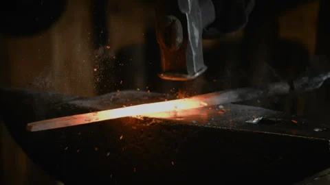 Blacksmith manually forging the molten metal on the anvil in slowmotion Stock Footage 89969745