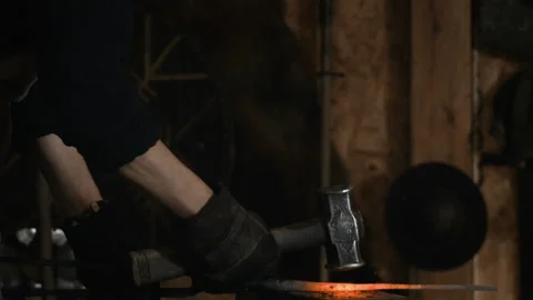 Blacksmith manually forging the molten metal on the anvil in slowmotion Stock Footage 89969760
