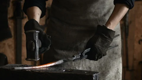 Blacksmith manually forging the molten metal on the anvil in slowmotion Stock Footage 89969763