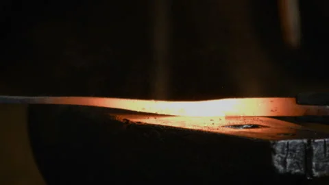 Blacksmith manually forging the molten metal on the anvil in slowmotion Stock Footage 89969783