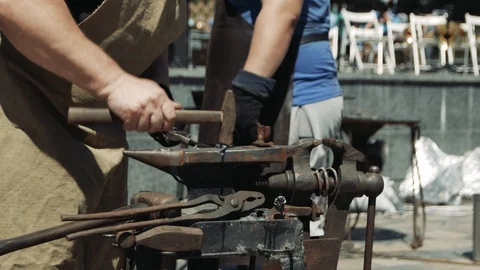 The blacksmith manually forging the molten metal on the anvil in smithy with  Stock-Footage 110836645