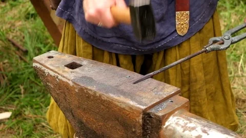 The blacksmith manually forging the molten metal on the anvil in smithy. Stock Footage 111066809