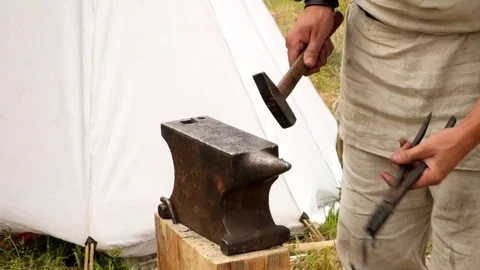 The blacksmith manually forging the molten metal on the anvil in smithy. Stock Footage 111066900