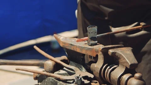 The blacksmith manually forging the molten metal on the anvil in smithy with  Stock-Footage 111265255