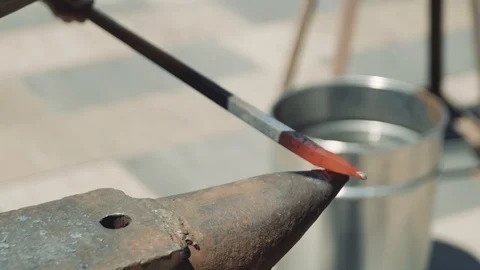 The blacksmith manually forging the molten metal on the anvil in smithy with  動画素材 111265584