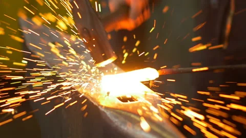 The blacksmith manually forging the molten metal on the anvil in smithy. 스톡 동영상 158405826