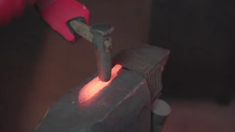 Blacksmith manually forging molten metal in smithy workshop. Damascus steel k Stock Footage 194486583