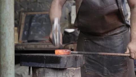 Blacksmith manually forging the molten metal. Close up of the hammer striking Stock Footage 223762484