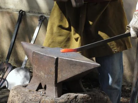 Blacksmith manually forging the molten metal with hammer on the anvil Foto stock