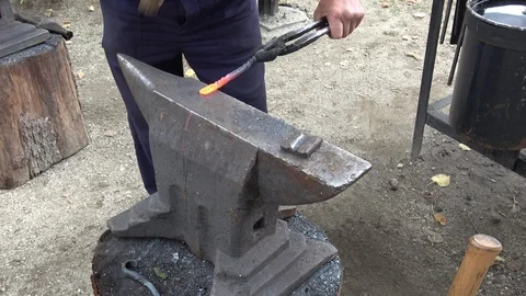 The blacksmith manually forging the red-hot metal on the anvil in smithy Stock Footage 114215182
