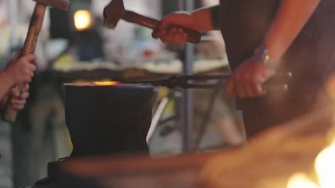 Blacksmith Mentors Child Hammering Hot Metal on Anvil Stock Footage 339751493