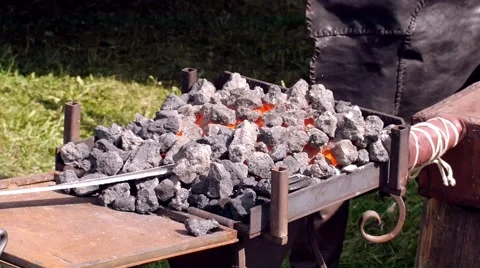A blacksmith models a bar of iron with hammer after took it from fire forge. Stock Footage 66238251