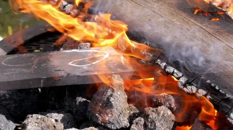 A blacksmith models a bar of iron with hammer after took it from fire forge. Stock Footage 66238358