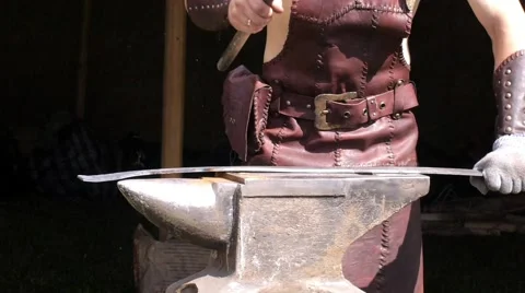 A blacksmith models a bar of iron with hammer after took it from fire forge. 動画素材 66239668