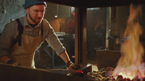Blacksmith Moving Charcoal to Keep Fire Burning in Forge Stock Footage 274390839