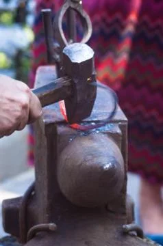 Blacksmith performs the forging of hot glowing metal on the anvil Foto stock