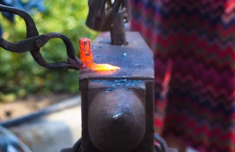 Blacksmith performs the forging of hot glowing metal on the anvil Foto stock
