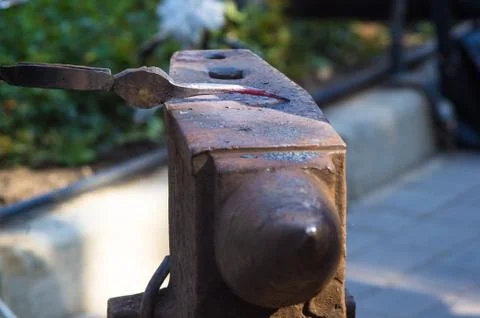 Blacksmith performs the forging of hot glowing metal on the anvil Stock Photos