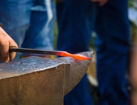 Blacksmith performs the forging of hot glowing metal on the anvil Foto stock